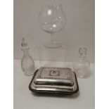 A silver plated covered serving dish with scrolling borders and an Armorial etched design of a