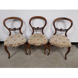 Three mahogany balloon back side chairs, Upholstered seats having floral design on a dark cream