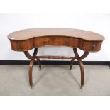 Reproduction walnut and mahogany kidney shaped dressing table, having three drawers and raised on