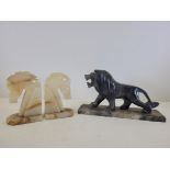 An Art Deco era carved and polished stone figure of a prowling lion, on a rectangular base, height
