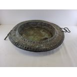 A late 19th or early 20th Century patinated metalwork deep twin handled dish, with repeating pattern