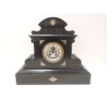 A Victorian slate mantelpiece clock, of architectural form, the ornate gilt surrounded enamel dial