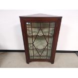 Mahogany corner unit with glazed front, Two internal scalloped shelves.