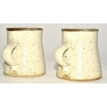 Michael Cole (Contemporary) a pair of stoneware ash and iron glazed thrown mugs, with strap