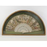 A late 19th Century framed and glazed silver and gilt paper fan, the sticks pierced with figures and