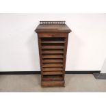 Tall oak filing cabinet, Having sliding internal shelves, lockable upwards roller door, and turned