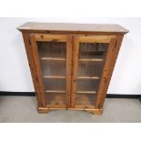 Modern pine glazed bookcase, With two glazed doors to the front and three internal glass shelves