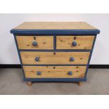 Painted pine two over two chest of drawers, part painted in blue, raised on four cylindrical