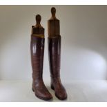 A pair of brown leather boots with lasts, height of boots 48cm, treen stands 70cm (2)