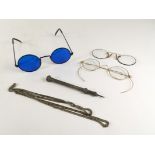 A group of three spectacles, including one with blue glass, a silver propelling pencil, the pencil