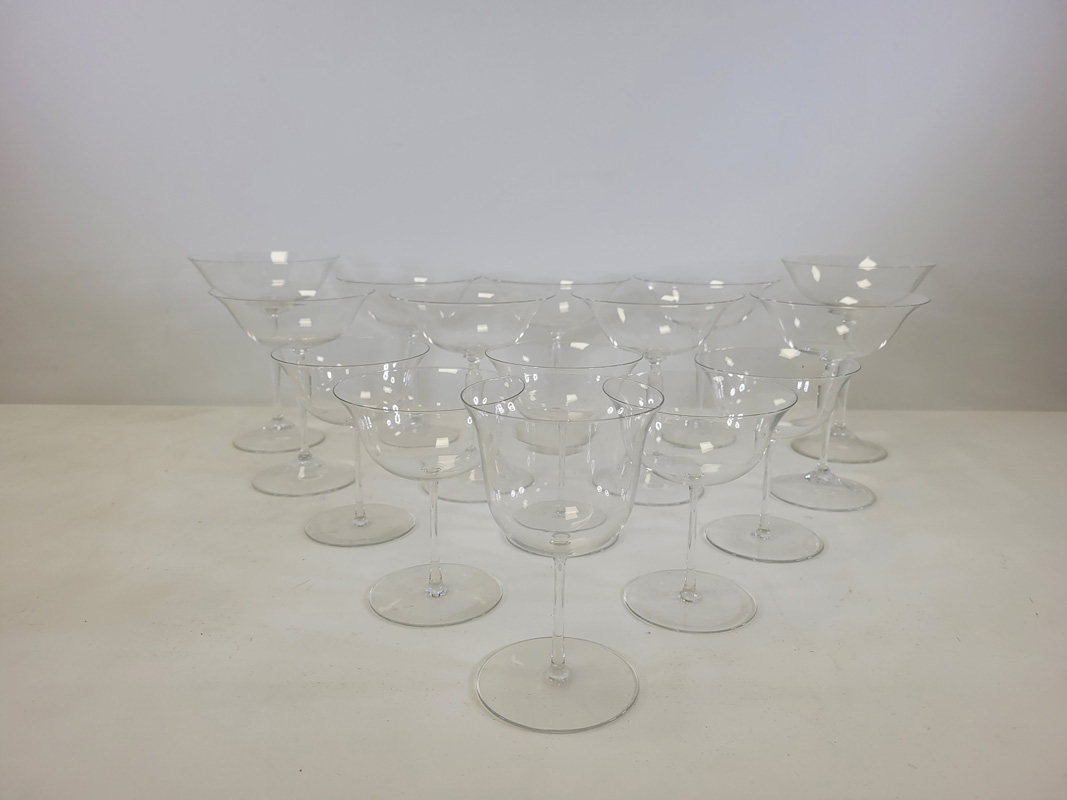 Twenty two drinking glasses with deep flaring bowls, the smaller examples with thin stems, height