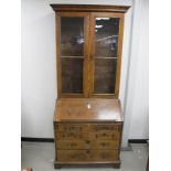 A Georgian figured walnut bureau bookcase, upper section with moulded cornice, two glass panelled