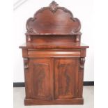 A Victorian mahogany chiffonier, shaped back with applied carving, a shelf supported by two turned