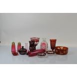 A collection of cranberry glass, including a rolling pin, 29cm, two sugar sifters, a cut glass