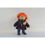 A Gabrielle Paddington Bear, with orange hat, dark blue coat and blue dunlop wellington boots,