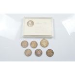 A collection of seven thalers, one in a plastic presentation case, five loose, the other mounted