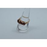 A 9ct gold three stone garnet dress ring, the three circular mixed cut stones in claw settings, ring