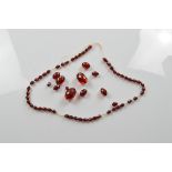 A string of translucent faceted 'cherry amber' beads, largest 3cm, smallest 1cm, 41cm long, cord