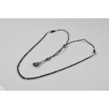 A certificated black diamond single strand necklace, of graduated design on silver cord and