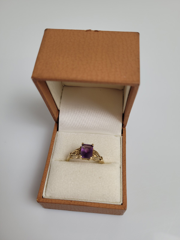 A 9ct gold amethyst dress ring, the mixed cut rectangular claw set amethyst with pierced set