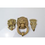 Three brass door knockers, two in the form lion heads with ring mounts, largest 18cm together with a