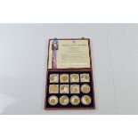 A collection of twelve pre decimal commemorative coins, each with silver plated coin inset with a