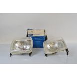 A pair of Ford Escort halogen headlamps, one boxed