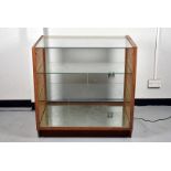 A glazed display case, with glass top, with two differently-sized internal glass shelves, complete