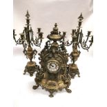 A late 19th or early 20th Century French brass garniture de chemineé raised on scrolling feet,
