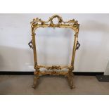 Large gilt framed screen, scroll decoration, metal handle to either side, set on castors. 82cm W x