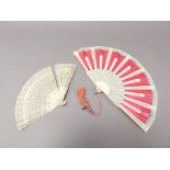 Two antique folding fans, one having pierced decoration, the other pink fabric ground. (2)