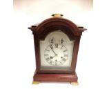 A 20th Century mahogany mantelpiece clock raised on two block and two brass feet, with three