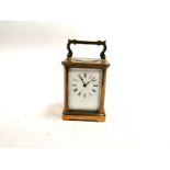 A brass carriage clock with enamel dial and Roman numerals engraved for 1899, with inspection