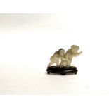 A Chinese hardstone carving of children holding hands, raised on a wooden stand, height 5cm