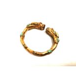 An Tibetan gilt bracelet, with confronting beasts heads inset with turquoise, diameter 8cm