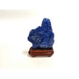 A Chinese lapis lazuli scholars style rock carved to form buildings in a mountainous landscape, with