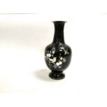 An Asian lacquered metal vase with inset mother of pearl decoration forming birds in blossoming