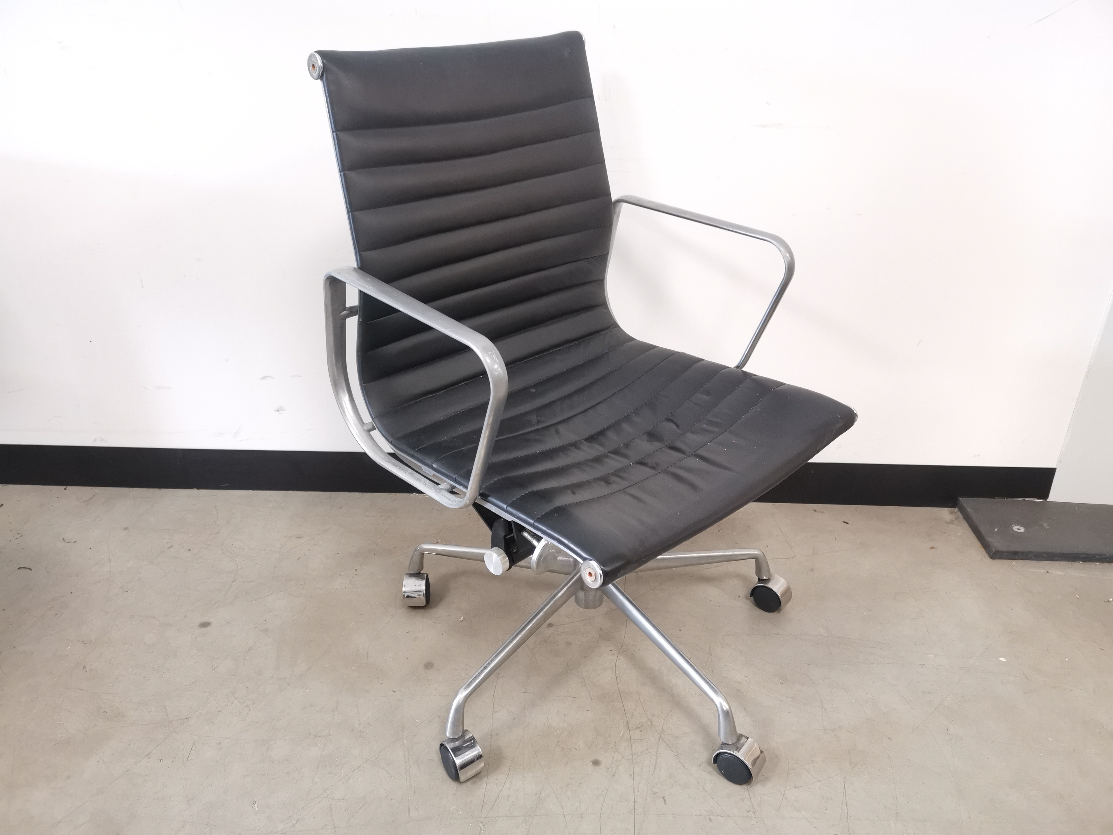 Mid 20th century designer desk chair, in the style of Eames, steel frame construction, black leather