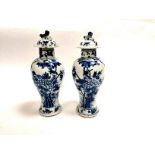 A pair of Chinese covered jars with underglaze blue decoration on a white ground, depicting