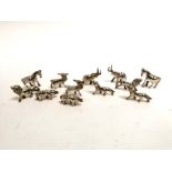 A group of Indian white metal menu holders, taking the form of wild animals including elephant,