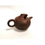 A Chinese Yixing stoneware teapot with protruding mythical beast's head, with calligraphic symbols