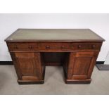 Walnut veneered green leather topped twin pedestal writing desk, with three draws to freize,