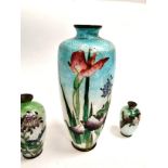 A group of three Japanese enamelled metalwork vases, each with a naturalistic floral design on a