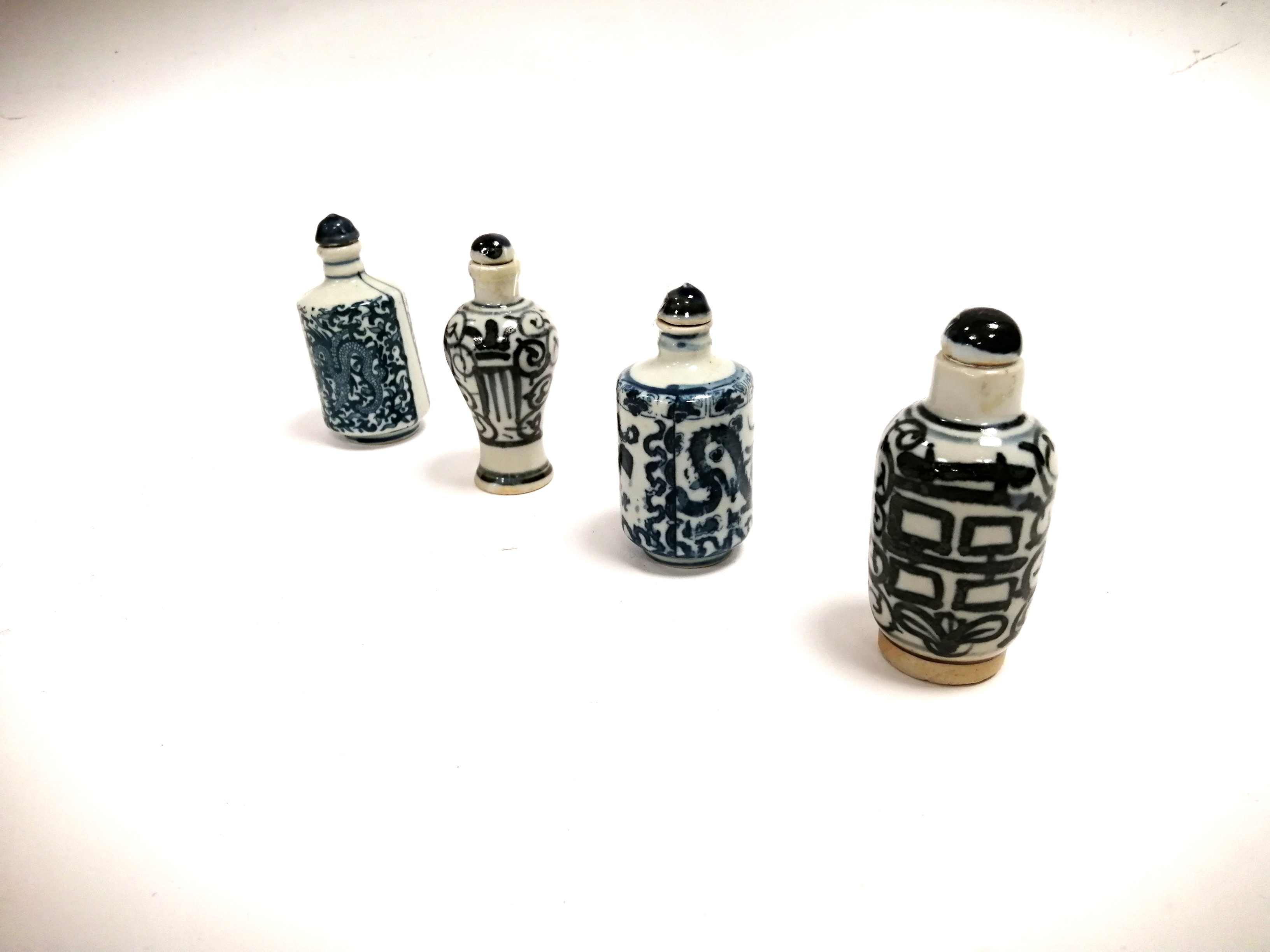 A group of four Chinese blue and white snuff bottles, two with encircling dragon designs with