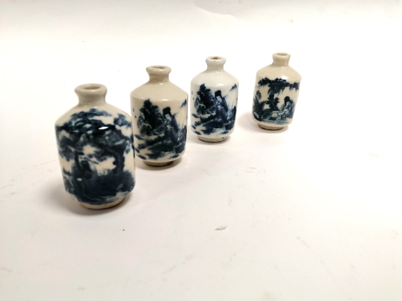 A group of four Chinese blue and white snuff bottles of identical form, two with the same female