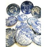 Eleven Asian blue and white plates in a variety of designs, to include a floriform example with