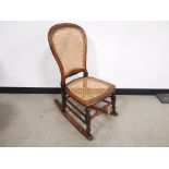 19th Century bergere rocking chair, with turned spindle supports. 41cm W x 64cm L x 88cm H
