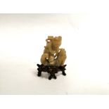 A Chinese hardstone figure of a mythical figure restraining a mythical Carp like creature, with a