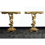 A pair of gilt painted console tables, Glass topped, supports in the form of puttos. (2)