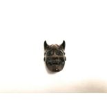 A Japanese boxwood carving a of demonic face with beaded eyes, having an artist's signature and